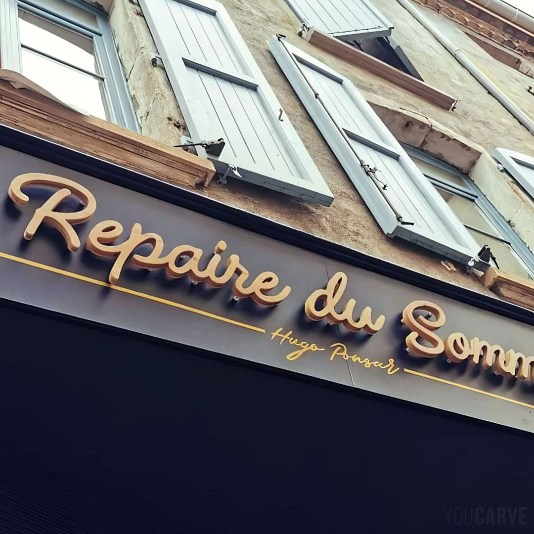 Réalisé par HZ Paintings, enseigne cave à vin Le Repaire du Sommelier Montbrison, réalisée en lettres découpées en bois (mélèze épaisseur 19 mm), fixation sur entretoises avec gabarit de perçage.