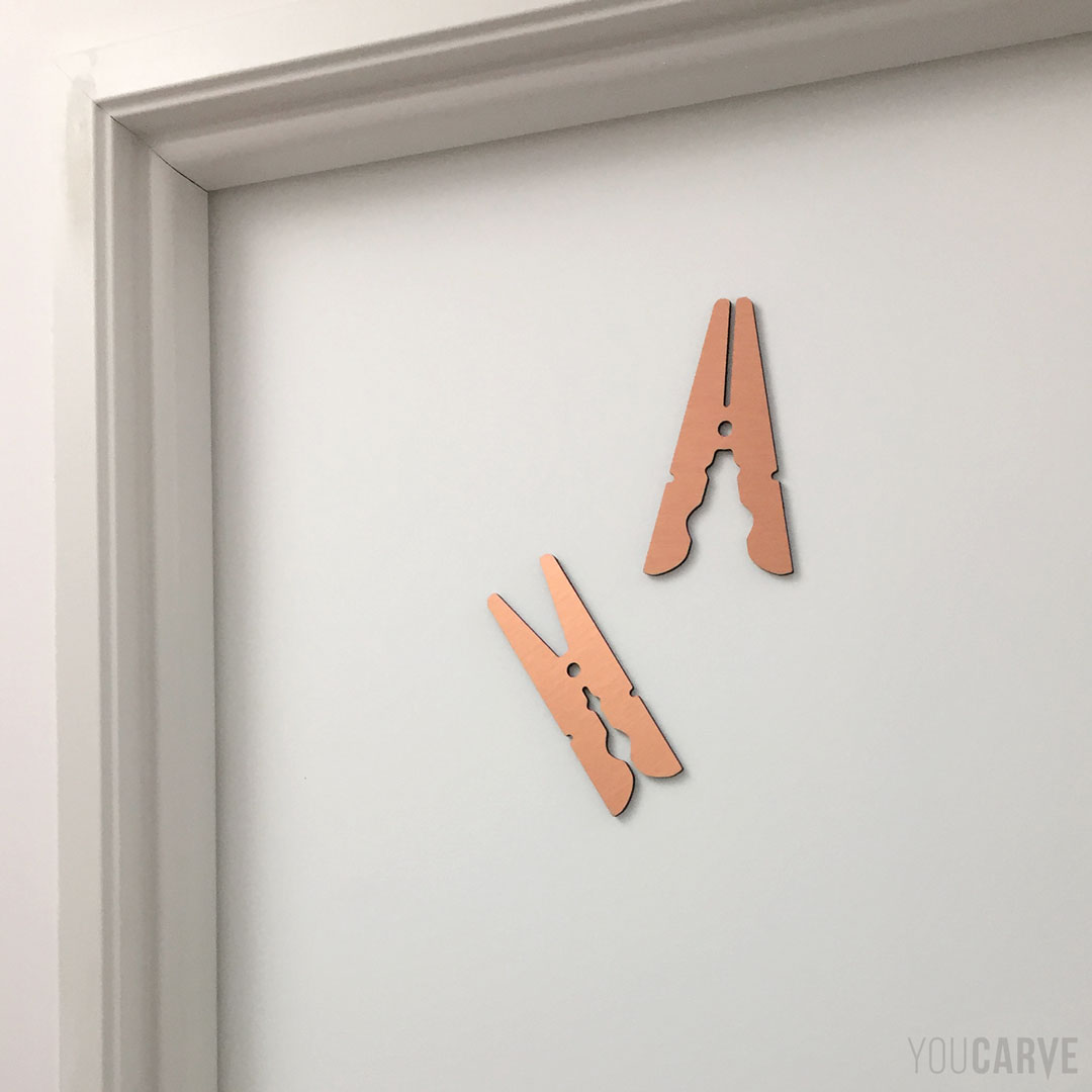 Décoration pour la signalétique d’une buanderie, forme de pince à linge découpée en dibond brossé cuivré (épaisseur 3 mm).
